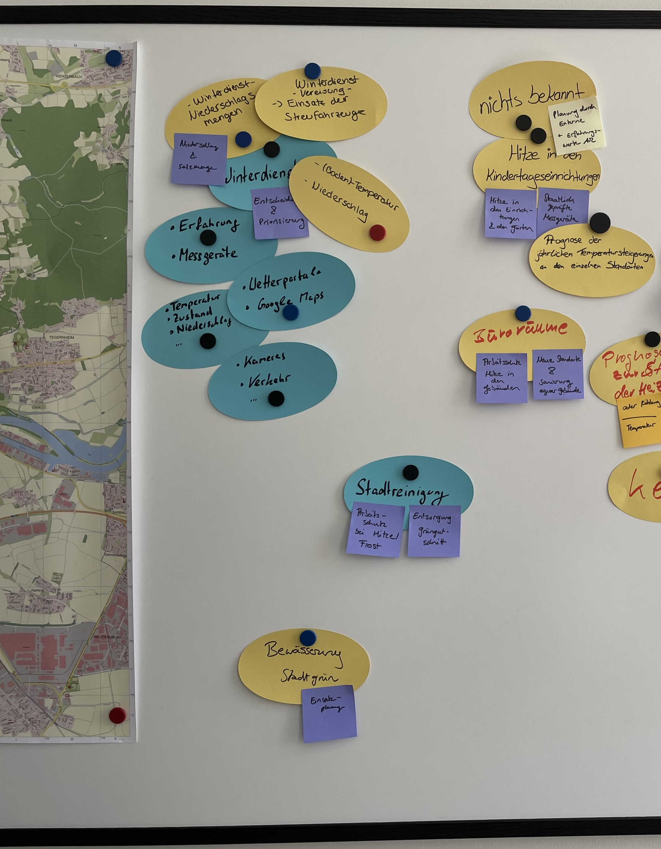Neben einer Karte sind mehrere Zettel auf einer Magnettafel angebracht. Sie veranschaulichen den Brainstorming-Prozess bei der Konzeption von Sensornetzwerken.